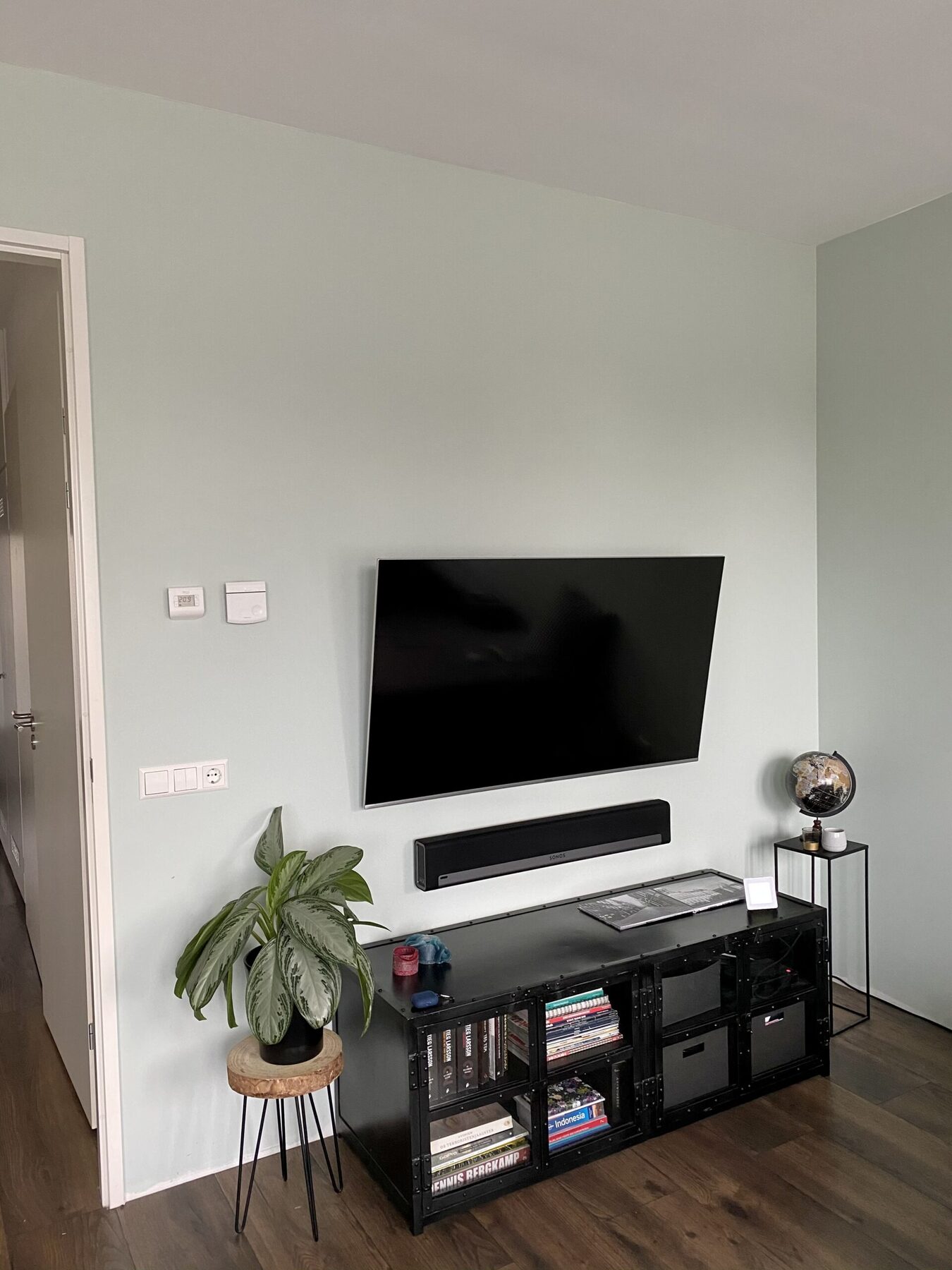 Woonkamer in een nieuwbouwappartement met matte, lichtgroene wand