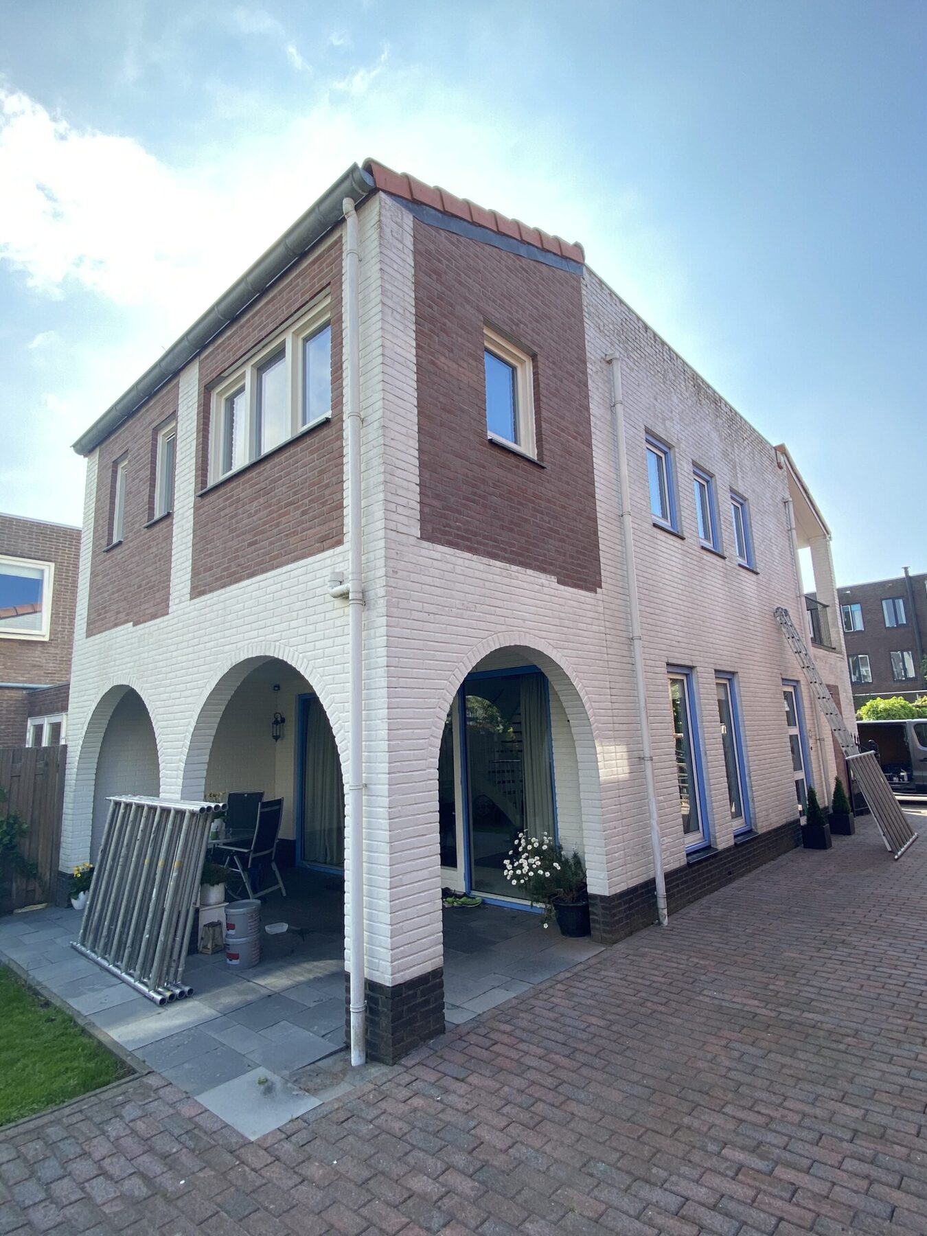 De woning vóór het schilderwerk, met deels kale baksteen